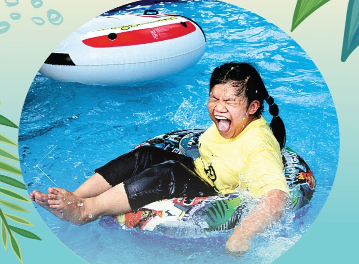 장애아동 여아가 수영장에서 튜브 위에 앉아 웃는 모습