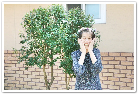 나무 앞에서화관을 쓰고 서서 꽃받침 포즈를 하고 있는 정소정장애가족의 모습