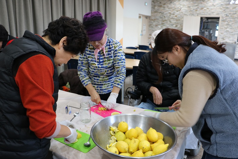 참여자들이 함께 레몬을 썰며 레몬청을 만들고 있는 사진