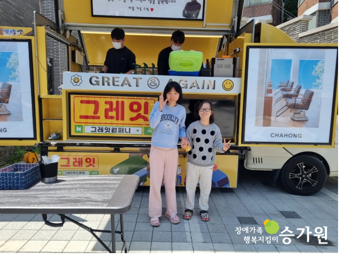 차홍 아르더에서 후원해주신 푸드트럭 앞에서 장애 아동 2명이 포즈를 취하는 모습 / 우측 하단 장애가족 행복지킴이 승가원CI