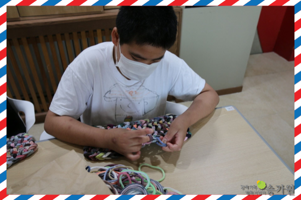 장애가족행복지킴이 승가원ci 삽입 / 남자 장애가족 한명이 집중하여 뜨개질을 하는 모습