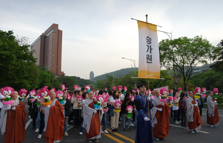 도로 한복판에 승가원이라고 써져있는 깃발을 든 기수 한 명을 시작으로 뒤에는 연꽃돌이 행렬등을 든 스님과 승가원 가족들이 행렬을 하고 있다.