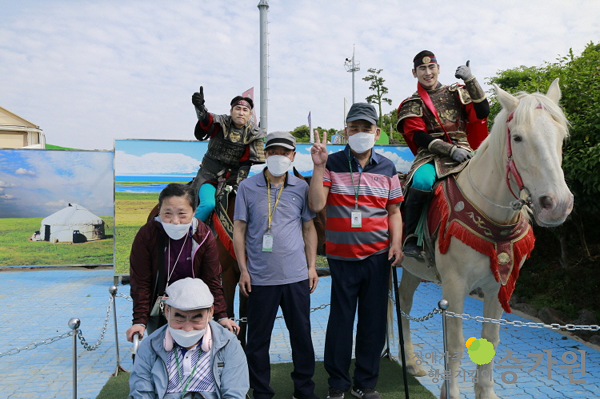 제주도 말과 함께 사진을 찍는 4명의 장애가족과 갑옷을 입은 2명의 기수의 모습 /장애가족행복지킴이 승가원ci