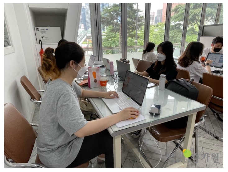 여섯명의 승가원 사회복지사들이 앉아서 노트북으로 승가원 신문을 제작하고 있는 모습, 장애가족행복지킴이 승가원 ci 로고 삽입
