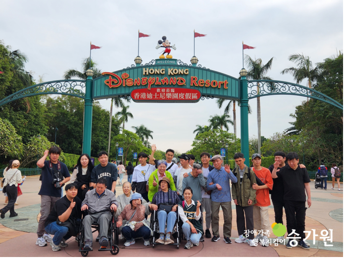 홍콩 디즈니월드 앞에서 사진을 찍은 장애가족들의 사진. 오른쪽 아래 승가원 ci삽입